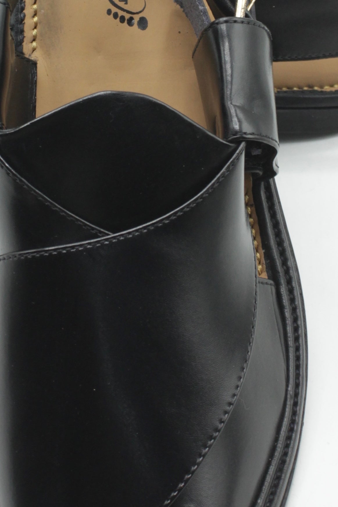 Close-up of a black Pure Leather sandal with a strap on a white background